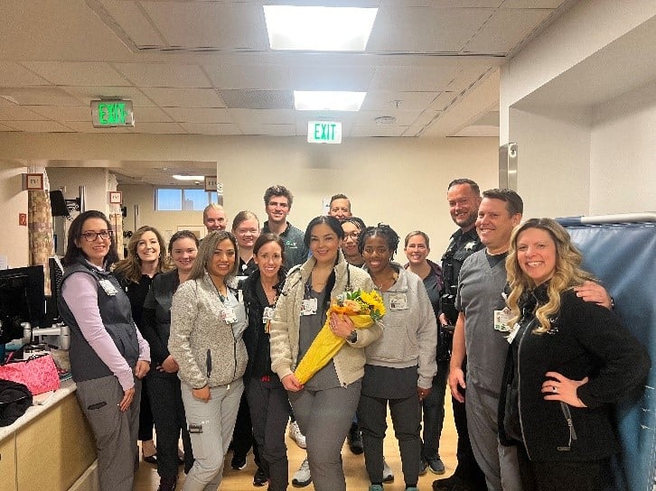 Group of nurses and staff celebrating in a hallway