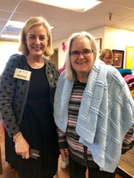 A photo of a volunteer with a woman wrapped in a cozy blanket