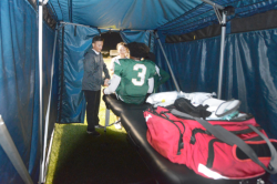 Podiatrist Kevin Miller, D.P.M., attends to a St. Patrick's High School football player inside the sports medicine tent during a game.