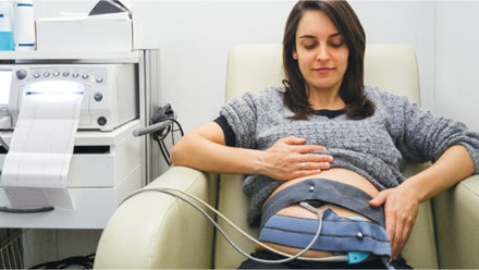 A pregnant woman a Fetal Non-Stress-Test while in a NST Recliner.