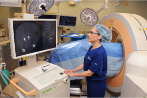 Dr. Edie Zusman is able to use the O-arm/Intraoperative CT and Stealth Image Guidance system (the pale orange and white piece of equipment behind her) to perform complex spinal surgeries.